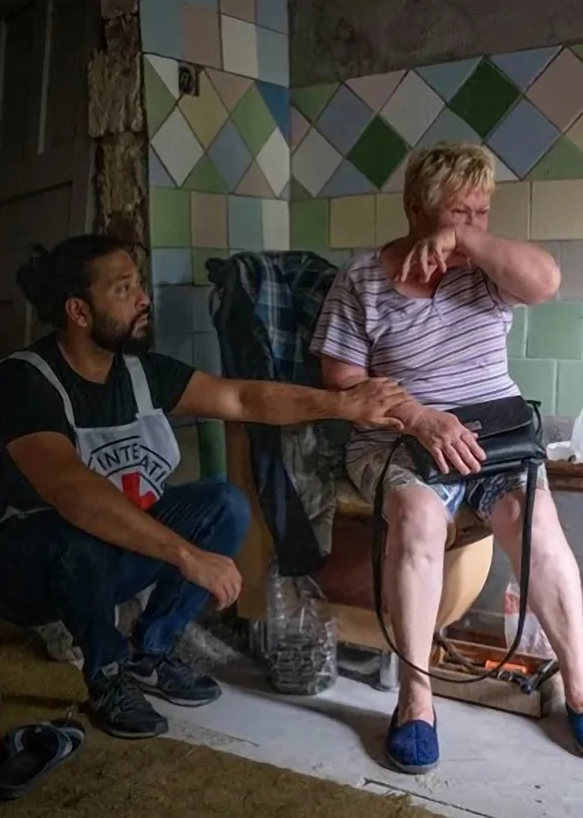 Trabalhador humanitário sentado ao lado de uma senhora em atendimento domiciliar